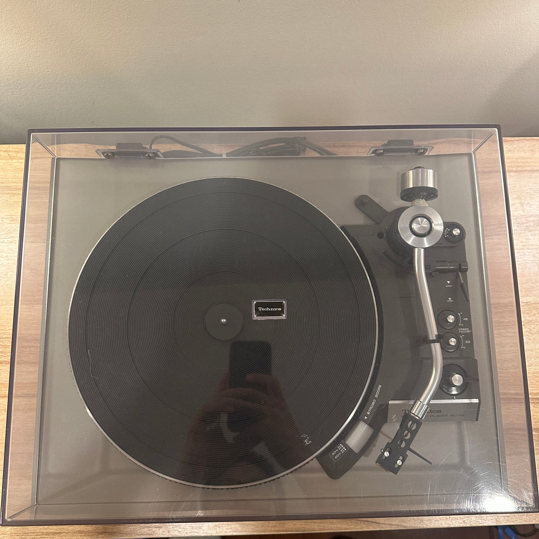 Turntable in a clear box on a wooden surface