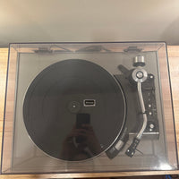 Turntable in a clear box on a wooden surface